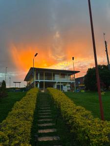 a building with a sunset in the background at Finca Hotel Vista Palmar - Eje Cafetero in Quimbaya