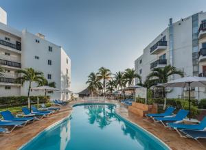 a pool with chairs and umbrellas at a resort at Imperial Las Perlas in Cancún