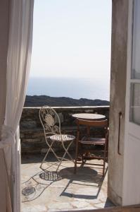 a table and chair on a balcony with the ocean at Chambre des amoureux, la Casamatta in Centuri