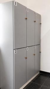 a row of white lockers with numbers on them at Tu Hostel Tucuman in San Miguel de Tucumán