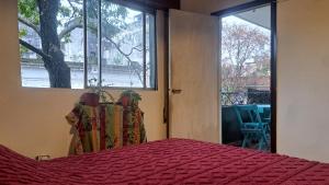 a bedroom with a bed and a large window at Tu Hostel Tucuman in San Miguel de Tucumán