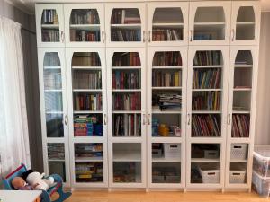 a large white cabinet filled with books at Red House at Kuusitie in Kittilä +16 photos
