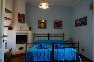 a bedroom with a bed with a blue comforter and a fireplace at B&B L'Antico Borgo in Milazzo