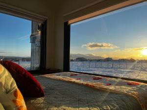 a bedroom with a large window with a view of the snow at Cabañas Julián Elías Roja in Puerto Natales