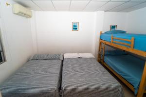 two bunk beds in a small room at Pargo, habitación privada de Flor de Lis Beach House in Playas