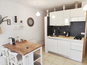 a kitchen with white cabinets and a wooden table at Bistra in Ajdovščina