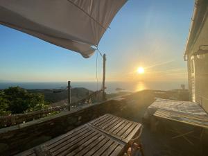 a view of the sunset from a house with an umbrella at Chambre des amoureux, la Casamatta in Centuri
