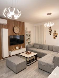 a living room with a couch and a table at Tirana, Beautifull Apartament Near Mother Teresa Int Airport in Tirana