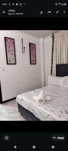 a bedroom with a bed with three pictures on the wall at The Rose Garden in Georgetown