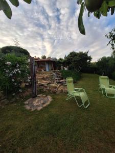 two lawn chairs sitting in the grass in front of a house at Eco romantica in Baratti