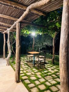 a wooden pergola with a table and two chairs at Eco romantica in Baratti