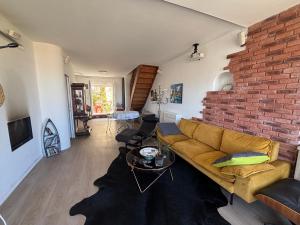 a living room with a couch and a brick wall at Parc National des Calanques, LA FLIBUSTE DES GOUDES Maison 2 chambres CLIMATISEE, jardins Jaccuzzi proche plage large vue mer PARKING reserve a l arrivee in Marseille