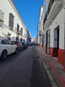 a street with cars parked on the sides of buildings at el rinconcito in Sanlúcar de Barrameda