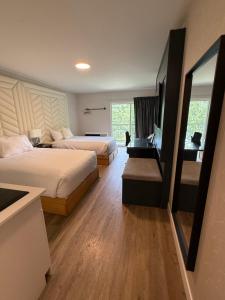 a hotel room with two beds and a desk at Hotel Civilia Lakeside by Civilia Golf Retreat in Clearwater