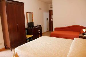 a bedroom with a bed and a desk with a computer at Abbadia in San Vito lo Capo