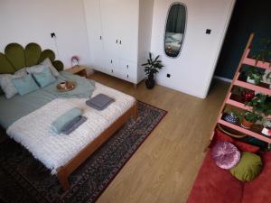 a bedroom with a large bed and a mirror at Kwiat Paproci Design Apartment Gdynia in Gdynia