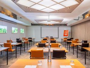 a classroom with tables and chairs and a whiteboard at ibis Lausanne Crissier in Lausanne