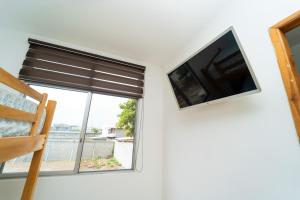 Ein Flachbildfernseher an der Wand neben einem Fenster in der Unterkunft Pangora, habitación privada de Flor de Lis Beach House in Playas + 12 Fotos