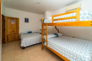 ein Schlafzimmer mit zwei Etagenbetten in einem Zimmer in der Unterkunft Pangora, habitación privada de Flor de Lis Beach House in Playas