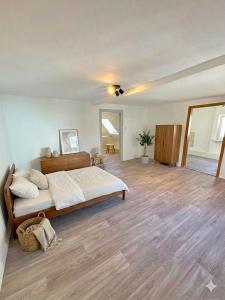 a bedroom with a large bed and a wooden floor at Wohnhaus mit besonderer Ausstrahlung in Bad Frankenhausen