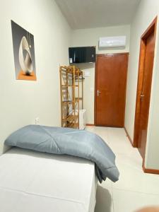 a bedroom with a bed with a blue pillow on it at Pousada Âncora - 14 Suítes completas com Ar, TV, Frigobar e Wi-Fi, para grupos ou viajantes individuais. in Gravataí