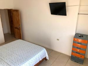 a bedroom with a bed and a tv on the wall at Estela, habitación privada de Flor de Lis Beach House in Playas +15 photos
