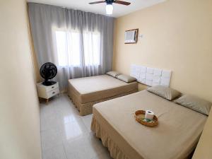 a small room with two beds and a window at Casa Marinho - Pé na praia in Saquarema +32 photos