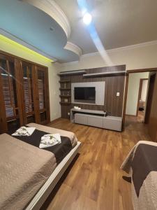 a bedroom with two beds and a flat screen tv at Dara House apart e eventos com piscina, sauna, Jacuzzi e área gourmet para festas in Cachoeira do Campo