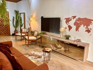 a living room with a large tv and a world on the wall at Hostel Amor por SP - BRÁS in São Paulo