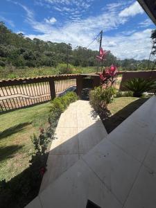 a walkway in a yard next to a fence at Dara House apart e eventos com piscina, sauna, Jacuzzi e área gourmet para festas in Cachoeira do Campo