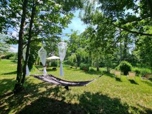 a hammock in a yard in a park at Domki nad rzeką Ełk in Prostki