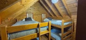 a bedroom with two bunk beds in a log cabin at Lodge De Ñuble in Las Trancas