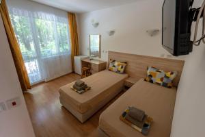 a small room with two beds and a television at Hotel Aia Kavatsi in Sozopol