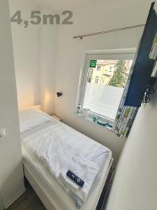 a small room with a bed and a window at Aparthotel Sanni in Bremen