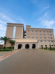 a large building with a palm tree in front of it at Class Hotel Americana in Americana +15 photos