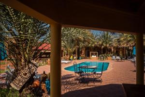 a view of a pool with a table and chairs at Oasis Tilogui-Luxury Hotel Restaurant and Desert Excursions In Zagora in Zagora +79 photos