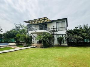 a house with a lawn in front of it at Rk farms in Noida