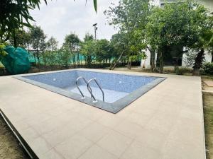 a swimming pool with two metal rails in a yard at Rk farms in Noida