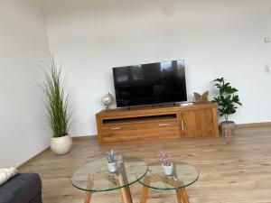 a living room with two glass tables in front of a tv at Kreide & Kissen in Lünebach