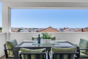 a dining table and chairs on a balcony at Shell Sky Luxury Penthouse with Private Pool in Zadar