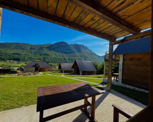 a picnic table on a patio with mountains in the background at Lagano Mountain Retreat - Via Ferrata & Restaurant in Gusinje