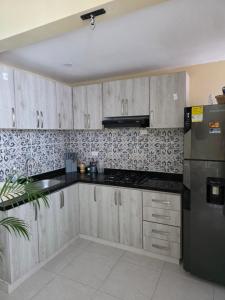 a kitchen with wooden cabinets and a stainless steel refrigerator at Paraiso Coveñas, Unidad con la mejor piscina in Coveñas