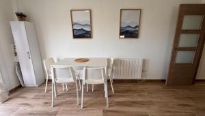 a dining room with a white table and white chairs at AuraGalega Sagres in Ribeira +9 photos