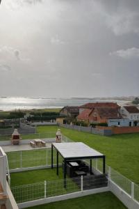 a table on a balcony with a view of the ocean at AuraGalega Sagres in Ribeira