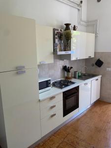 a kitchen with white cabinets and a white refrigerator at Il Limone A San Pietro - Vatican in Rome