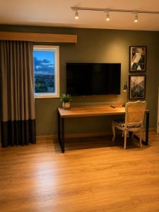 a room with a desk with a television and a chair at ibis Catanduva in Catanduva