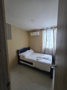 a small bedroom with a bed and a window at Paraiso Coveñas, Unidad con la mejor piscina in Coveñas +14 photos