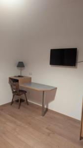 a desk with a chair and a television on a wall at Hotel Zachskorn UG in Erdweg