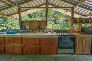 a kitchen with a stove and a counter top at Casa Aire Libre - Jungle immersion - Natural pool - Waterfall in Puerto Jiménez