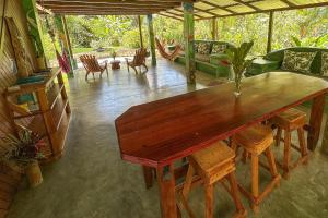 a large wooden table in a living room at Casa Aire Libre - Jungle immersion - Natural pool - Waterfall in Puerto Jiménez